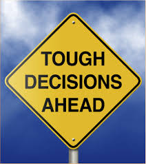 The image displays a standard yellow sign reading "Tough Decisions Ahead" against a blue sky indicating that an effective approach for making tough decisions lies ahead.